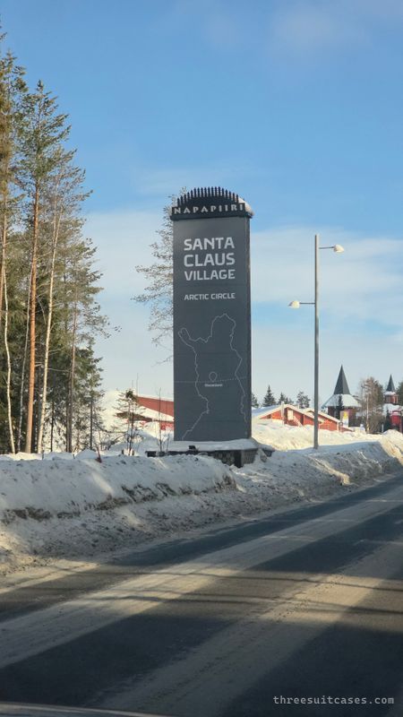Santa Claus Village Arctic Circle tower beside a snowy road in Rovaniemi